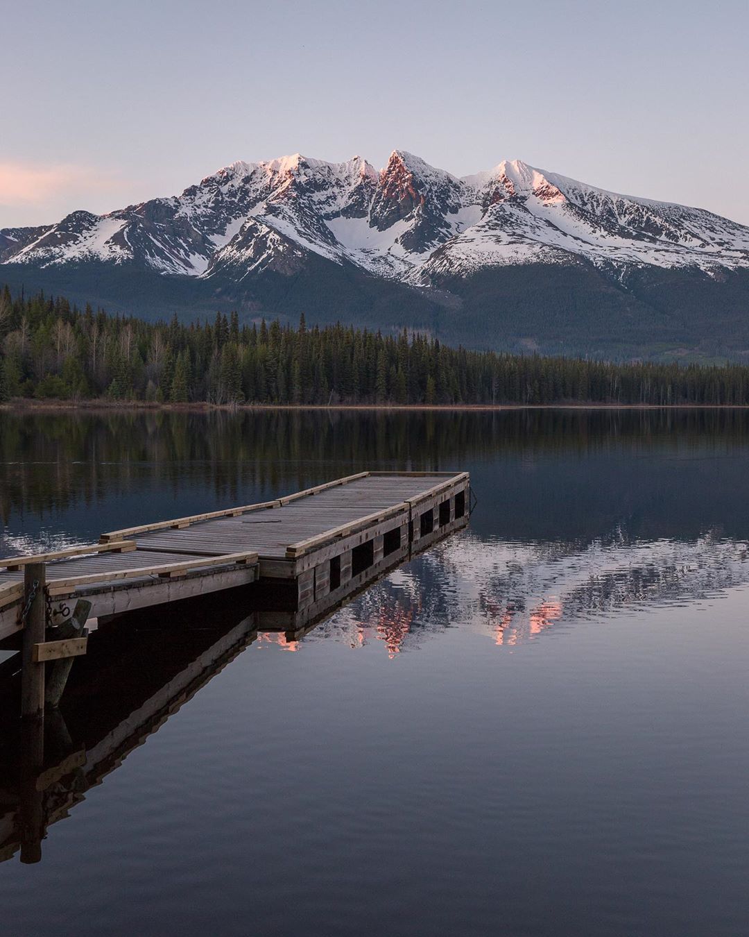 photo by Jason Mcintosh caption reads: Gravel roads always lead to the best places. Northern BC lake vibes, with Hudson Bay Mountain in the distance.  I can still hear the Loons! 
.
.
.
.
.
.
.
.
.
.
.
.
.

#hudsonbaymountain #smithers  #smithersbc #smithersvibe #dennislakebc #explorebc #explorecanada #northernbc #bulkleyvalley #terracebc #bcisbeautiful #reflection #lakevibes #summervibes #dailyviewbc #britishcolumbia #pnw #cascadiaexplored #canadiancreatives #exploremore #canadasworld #canada #mountainlife #camping #tourcanada #outdoortones #pnwwilderness @hellobc #52weeksofnature #roamtheplanet